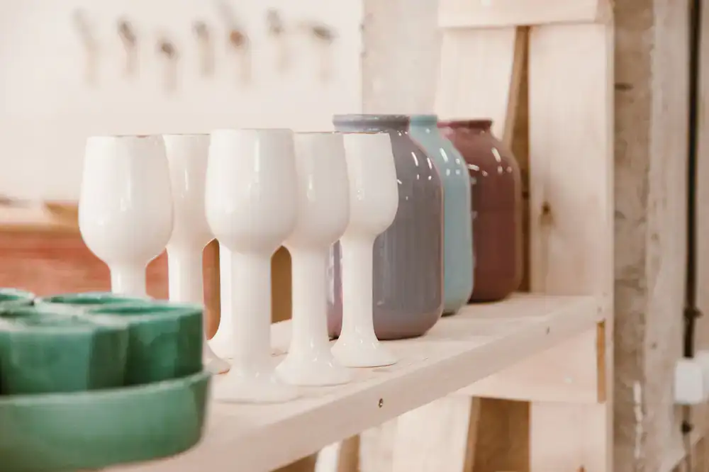 A row of handcrafted hats displayed on wooden stands in the studio